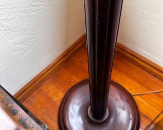 Round wood base of floor lamp with lavender lace shade