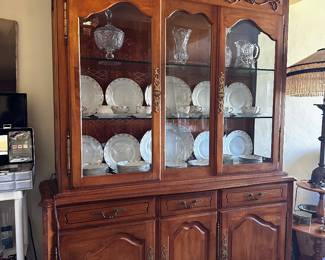 China cabinet still working on getting lights boobs may be burned out is 60 inches wide 19 inch deep on base and yes, it is in two pieces for Moving hallelujah tons of storage below drawer has custom insert for flatware proudly marked Ethan Alan