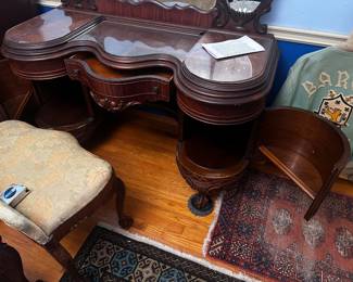 Vanity shown with side doors open with space below and an upper shelf on half circle. Top has three carved glass protectors, dresser, and chest also carved glass tops.
