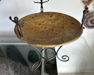 Brutalist style hammered metal bowl held by three welded figures 