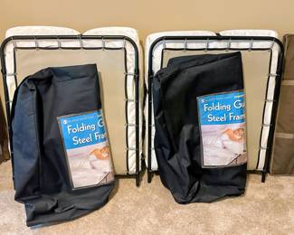 Two fold-out cots with mattresses and storage bags - like new.