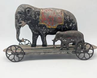 Tin toy elephant with baby on wheels