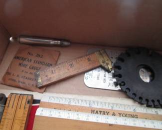 Many vintage slide rules, rulers, tape measures