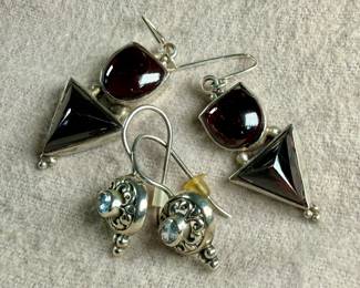 This lot features two pairs of vintage sterling silver earrings. One pair features garnets and the other with aquamarine.