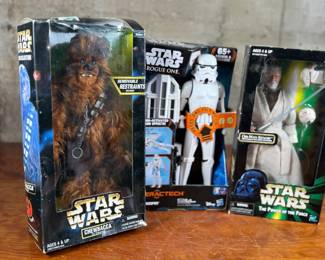 Three Star Wars action figures, all in original unopened packaging. Includes Chewbacca with removable restraints, Imperial Stormtrooper from the Interactech series with sound effects, and Obi-Wan Kenobi from The Power of the Force series. Each figure retains original branding and age recommendations.