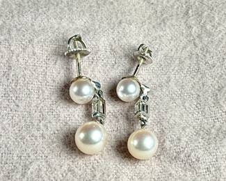 This lot features a beautiful set of genuine pearl earrings, each with a genuine diamond and set in 14k gold. Total approx. weight of 3.50 grams.