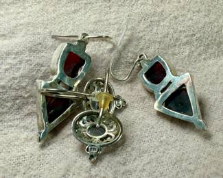 This lot features two pairs of vintage sterling silver earrings. One pair features garnets and the other with aquamarine.