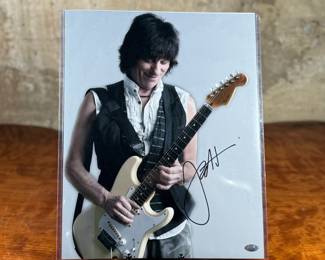 This lot features an iconic photo of Jeff Beck of the Jeff Beck Group. Signed by the photographer possibly, with a cert tag on the lower right as shown in photos. This photo measures, 14” H x 11” W.
