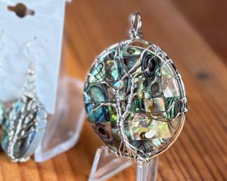 This lot features a set of sterling silver earrings and pendant featuring abalone in excellent condition.