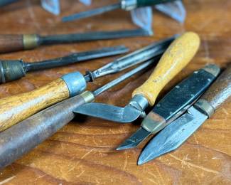 Vintage woodworking tools, featuring items engraved with marks like ‘G.S. Osborne & Co., Newark N.J.’, ‘Buck Bros.’, and ‘Craftsman’. Includes a variety of tools with wood and metal construction, such as knives, chisels, and carving tools. Some tools exhibit wear consistent with use and age. A practical collection for tool enthusiasts or woodworkers.