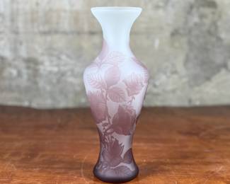 This lot features an Art Nouveau style cameo glass vase, featuring etched floral patterns in a purple or amethyst hue and measures, 10.5” H. Likely circa 1950s.