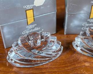 Two Gorham Crystalites Collection swirl candleholders made of lead crystal. Packaged in the original boxes, which show signs of wear and damage. The candleholders depict a modern swirl design and are in good condition with no visible chips or cracks.