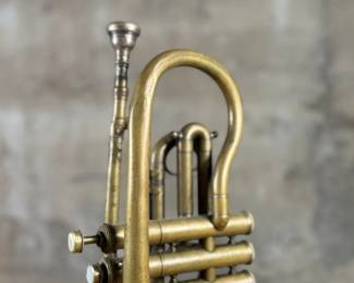 An antique Marceau brass trumpet and case in fair condition.