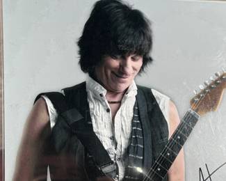 This lot features an iconic photo of Jeff Beck of the Jeff Beck Group. Signed by the photographer possibly, with a cert tag on the lower right as shown in photos. This photo measures, 14” H x 11” W.