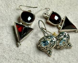 This lot features two pairs of vintage sterling silver earrings. One pair features garnets and the other with aquamarine.