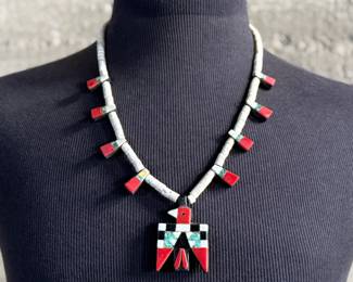 This lot features an antique Santo Domingo Pueblo (Kewa) Thunderbird necklace, an iconic style frequently made during the Depression era using repurposed materials like plastic from battery casings, phonograph records, and turquoise. This necklace has mosaic inlay typically utilizing turquoise, coral, and black jet (often repurposed plastic). These necklaces are highly collectible examples of Southwestern cultural heritage and resourcefulness. Handcrafted by artists from the Kewa (Santo Domingo) Pueblo, with many historic examples dating back to the 1920s–1940s. Measures, 22”.