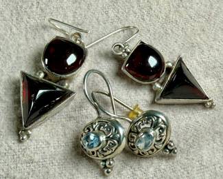 This lot features two pairs of vintage sterling silver earrings. One pair features garnets and the other with aquamarine.