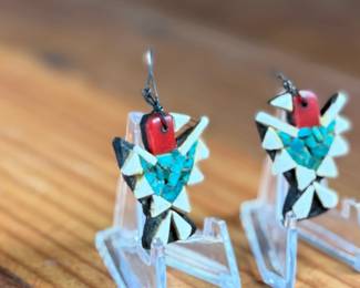 This lot features a pair of vintage Santo Domingo Depression Era Thunderbird earrings. These earrings are handcrafted using mosaic inlay techniques with turquoise chips, coral bits, and recycled materials like car battery casings. Produced by Native American artists at the Santo Domingo Pueblo (now Kewa Pueblo) in New Mexico during the 1930s.