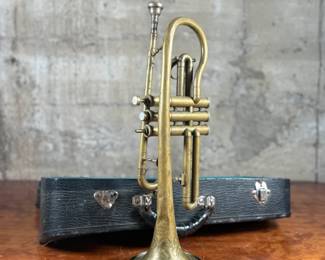 An antique Marceau brass trumpet and case in fair condition.
