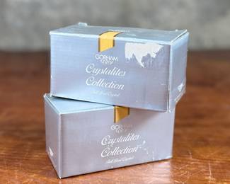 Two Gorham Crystalites Collection swirl candleholders made of lead crystal. Packaged in the original boxes, which show signs of wear and damage. The candleholders depict a modern swirl design and are in good condition with no visible chips or cracks.