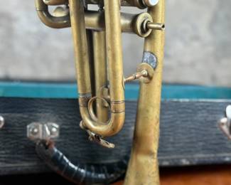 An antique Marceau brass trumpet and case in fair condition.