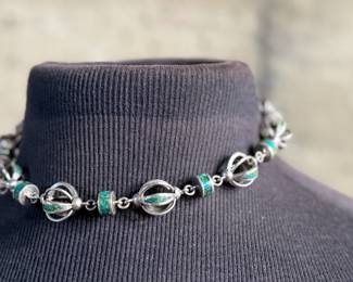 This lot features a beautiful necklace crafted from sterling silver and inlaid Malachite. Measures, 17” with a total approx. weight of 78.59 grams.