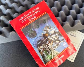 Wooden display case by Health Edco/WRS, containing educational models on the consequences of drug abuse. Case includes realistic anatomical representations of organ damage, such as brain infection, heart infection, vein damage, and birth defects. Accompanied by a ‘Substance Abuse Identification Guide’ and foam padding for storage. Case is equipped with clasps and a black handle. Exterior shows scratches and wear. Measures (closed), 27.75” H x 14” W.