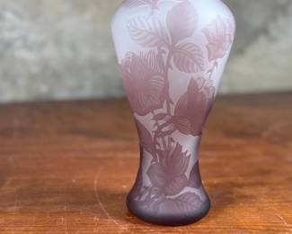This lot features an Art Nouveau style cameo glass vase, featuring etched floral patterns in a purple or amethyst hue and measures, 10.5” H. Likely circa 1950s.