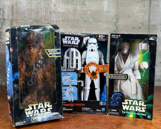 Three Star Wars action figures, all in original unopened packaging. Includes Chewbacca with removable restraints, Imperial Stormtrooper from the Interactech series with sound effects, and Obi-Wan Kenobi from The Power of the Force series. Each figure retains original branding and age recommendations.