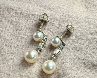 This lot features a beautiful set of genuine pearl earrings, each with a genuine diamond and set in 14k gold. Total approx. weight of 3.50 grams.