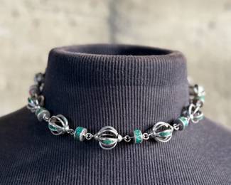 This lot features a beautiful necklace crafted from sterling silver and inlaid Malachite. Measures, 17” with a total approx. weight of 78.59 grams.