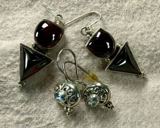This lot features two pairs of vintage sterling silver earrings. One pair features garnets and the other with aquamarine.