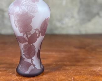 This lot features an Art Nouveau style cameo glass vase, featuring etched floral patterns in a purple or amethyst hue and measures, 10.5” H. Likely circa 1950s.