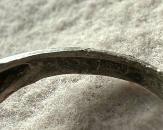 Sterling silver ring featuring a vibrant turquoise cabochon centerpiece. The band is ornately designed with detailed organic elements resembling leaves or vines. The turquoise stone is prominently set, securely held by prongs. The interior of the band shows slight wear, consistent with age and previous use. Comes in a size 6.