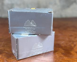 Two Gorham Crystalites Collection swirl candleholders made of lead crystal. Packaged in the original boxes, which show signs of wear and damage. The candleholders depict a modern swirl design and are in good condition with no visible chips or cracks.