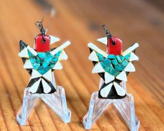 This lot features a pair of vintage Santo Domingo Depression Era Thunderbird earrings. These earrings are handcrafted using mosaic inlay techniques with turquoise chips, coral bits, and recycled materials like car battery casings. Produced by Native American artists at the Santo Domingo Pueblo (now Kewa Pueblo) in New Mexico during the 1930s.