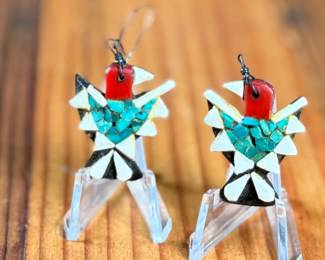 This lot features a pair of vintage Santo Domingo Depression Era Thunderbird earrings. These earrings are handcrafted using mosaic inlay techniques with turquoise chips, coral bits, and recycled materials like car battery casings. Produced by Native American artists at the Santo Domingo Pueblo (now Kewa Pueblo) in New Mexico during the 1930s.