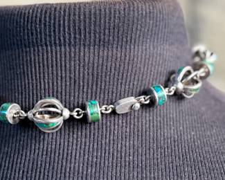 This lot features a beautiful necklace crafted from sterling silver and inlaid Malachite. Measures, 17” with a total approx. weight of 78.59 grams.