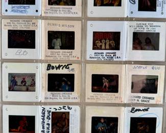 Vintage 35mm slides primarily organized in a transparent holder. Each slide features labels with the name “Richard Creamer” and addresses in Beverly Hills and Los Angeles, CA. Subjects documented include notable music acts such as The Police, David Bowie, ELO, and others. Handwritten annotations accompany several slides. Great condition for archival or display purposes.