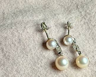 This lot features a beautiful set of genuine pearl earrings, each with a genuine diamond and set in 14k gold. Total approx. weight of 3.50 grams.