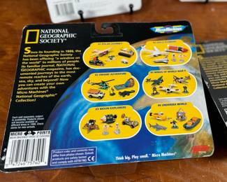 Two Matchbox Thunderbirds action figures (Scott Tracy and Alan Tracy) on original carded packaging, and two Micro Machines National Geographic Collections: #3 Moon Explorers and #4 Space Pioneers. All items are in original unopened packaging with visible wear consistent with age. Educational and collectible sets representing iconic figures and space exploration themes.