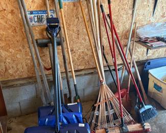 Assorted Snow Shovels, Brooms, and Rakes