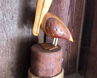 Hand carved wooden pelican on a post