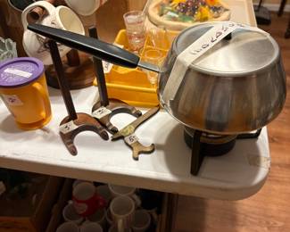 Fondue pot with lid on end, miscellaneous cups on stand and more in kitchen
