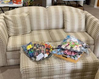 Sofa bed with decorative pillow and ottoman with storage.