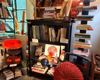 Lots of really good cookbooks and some local stuff in the collection. I’m attracted to that velvet poof pillow…