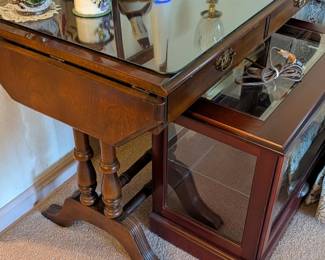 SHORT LIGHTED CURIO IN FRONT, DROP LEAF TABLE BEHIND