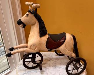 Decorative folk art tricycle with a hand carved wooden horse body