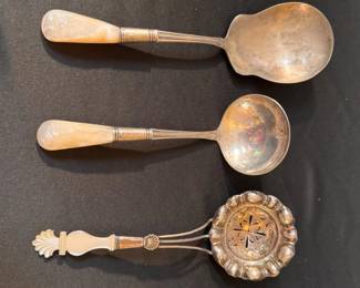 Both sterling silver and unmarked serving utensils with mother of pearl handles