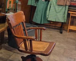 Vintage desk chair swivels and rocks collectors Girl Scout uniform and memorabilia date back to 1950's and beyond.